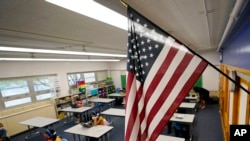 En esta fotografía de archivo del 25 de agosto de 2020, una bandera estadounidense cuelga en un salón de clases en una escuela pública de Denver, Colorado. 