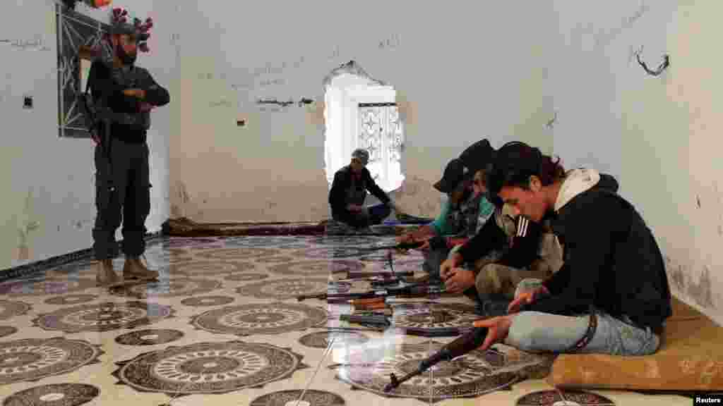 Free Syrian Army fighters prepare their weapons inside a room in Kafr Naboudeh in Hama countryside, September 2, 2013.