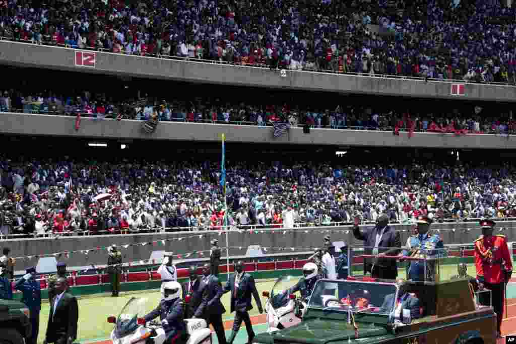 Kenya's outgoing president Mwai Kibaki waves as he arrives for the inauguration of Uhuru Kenyatta at Kasarani stadium, Nairobi, April 9, 2013.