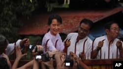 Hands reach to touch the hand of Burma's pro-democracy leader Aung San Suu Kyi after her release from house arrest in Rangoon, 13 Nov 2010