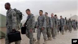 U.S. servicemen line up to board a bus as they begin their journey home at al-Asad Air Base west of Baghdad, Iraq, Tuesday, Nov. 1 , 2011.