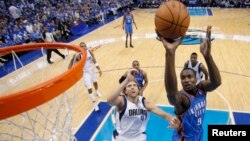 Serge Ibaka d’ Oklahoma City Thunder (9) amorce une attaque vers le panier face à Dirk Nowitzki de Dallas Mavericks (41) lors d’un match de la NBA à Dallas, Texas, 7 mai 2011.