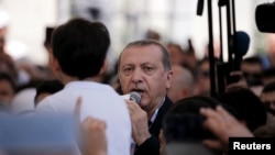 Le président turc Recep Tayyip Erdogan donne un discours à la foule lors des obsèques publiques des victimes du putsch à Istanbul, le 17 juillet 2016. 