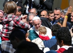 FILE - Pope Francis meets migrants at the Moria refugee camp on the Greek island of Lesbos, April 16, 2016.