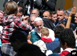 FILE - Pope Francis meets migrants at the Moria refugee camp on the Greek island of Lesbos, April 16, 2016.