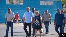 Le vice-président cubain Miguel Diaz-Canel et son épouse Lis Cuesta Peraza, encadrés par les services de sécurité, dans un centre de vote lors des élections des représentants nationaux et provinciaux de l'Assemblée nationale à Santa Clara, Cuba, dimanche 11 mars 2018.