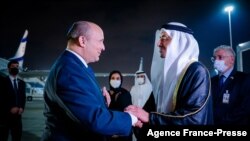 UAE Minister of Foreign Affairs and International Cooperation Sheikh Abdullah bin Zayed Al Nahyan (R) welcomes Israeli Prime Minister Naftali Bennett upon his arrival at the Presidential Terminal at Abu Dhabi International Airport, Dec. 12, 2021.