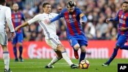 Lionel Messi et Cristiano Ronaldo au coude à coude lors d'un match à Barcelone, Espagne, le 3 décembre 2016.