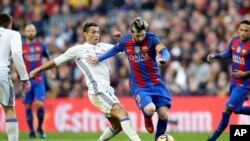 Lionel Messi, au centre, à gauche, attaqué par Cristiano Ronaldo lors d'un classico en Liga au Camp Nou, Barcelone le 3 décembre 2016. (AP Photo/Manu Fernandez)