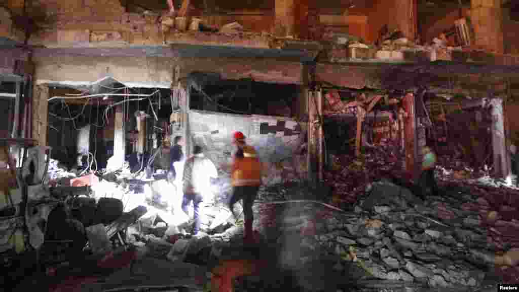 Civilians and rescuers search under rubble at a site hit by what activists say was a Scud missile from forces loyal to Syria's President Bashar al-Assad in Raqqa, Nov. 28, 2013. 