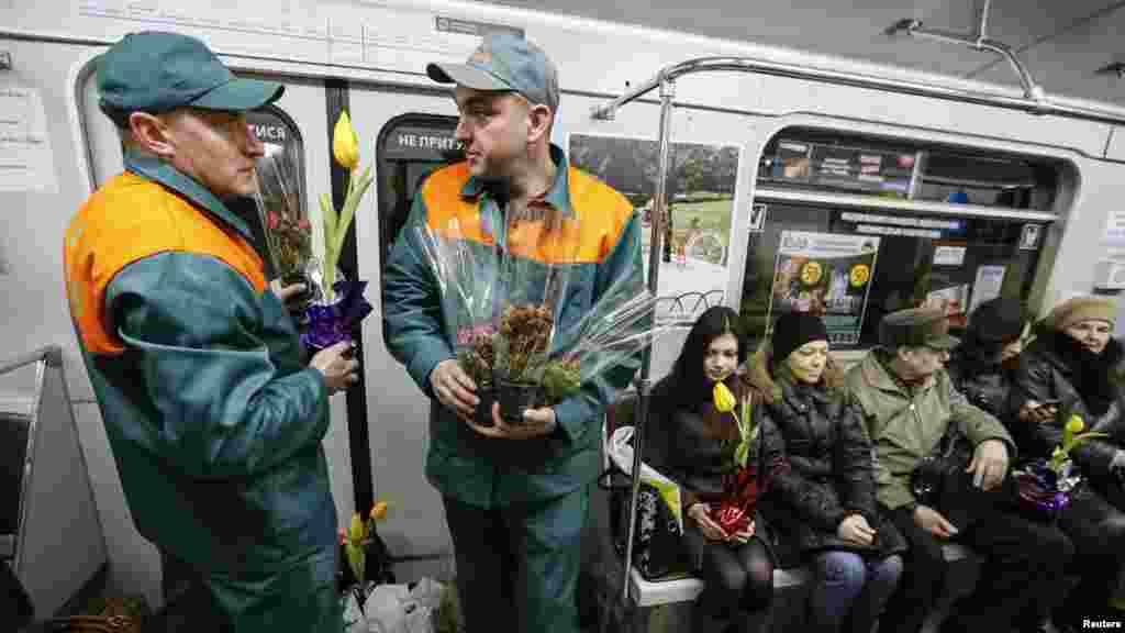 Para petugas kereta bawah tanah Kyiv, Ukraina, membawa bunga untuk dibagikan kepada penumpang perempuan menjelang Hari Perempuan Internasional (2/3). (Reuters/Gleb Garanich)