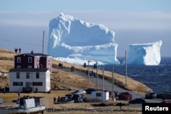 Residents view the first iceberg of the season as it passes the South Shore, also known as "Iceberg Alley", near Ferryland Newfoundland, Canada April 16, 2017