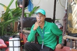 A man smokes a cigarette in a public area in Phnom Penh, Cambodia, on May 23, 2016. (Leng Len/VOA Khmer)