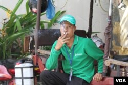 A man smokes a cigarette in a public area in Phnom Penh, Cambodia, on May 23, 2016. (Leng Len/VOA Khmer)