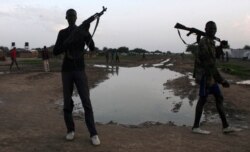 FILE - Youths from the Luo Nuer tribe carry their guns as they walk home in Yuai Uror county, in South Sudan, July 23, 2013.