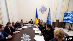 FILE - Ukrainian President Volodymyr Zelenskiy, center, leads a meeting of the emergency response team on the crash of the Ukraine International Airlines plane in Iran, in Kyiv, Jan. 9, 2020.