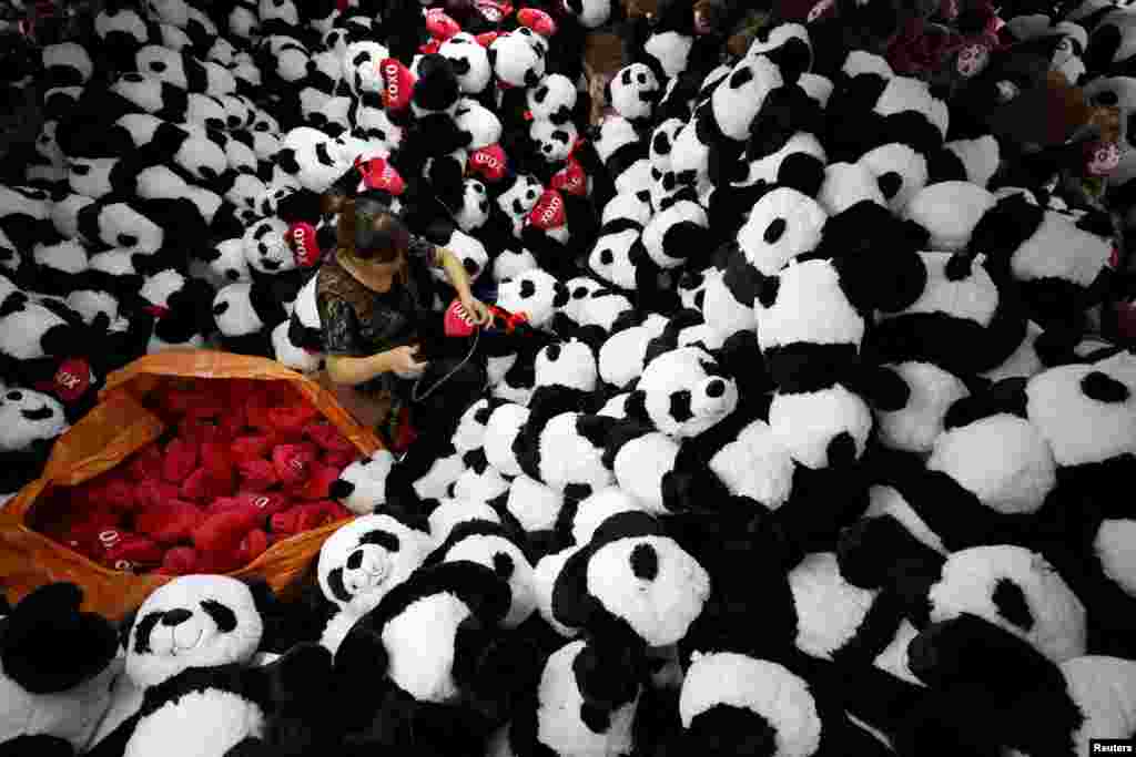 A worker processes panda soft toys for export to American and European markets at a factory in Lianyungang, Jiangsu province, China, Oct. 9, 2017.