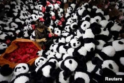 A worker processes panda soft toys for export to American and European markets at a factory in Lianyungang, Jiangsu province, China, October 9, 2017.