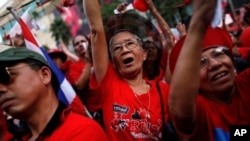 Thai anti-government 'red shirt' protesters react as their leader addresses them at Bangkok's shopping district, 19 Dec 2010