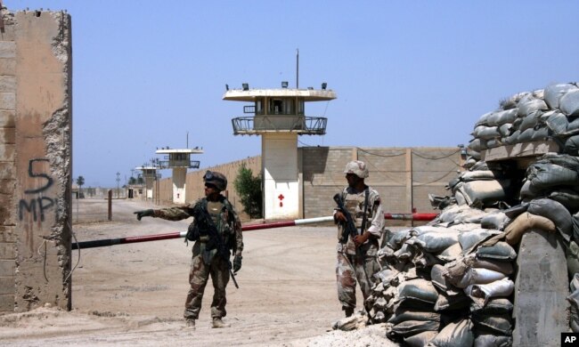 FILE - Iraqi army soldiers stand guard at the Abu Ghraib prison on the outskirts of Baghdad, Iraq, Sept. 2, 2006.