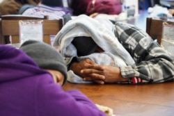 People take shelter at Gallery Furniture store which opened its door and transformed into a warming station after winter weather caused electricity blackouts in Houston, Texas, U.S. February 17, 2021.