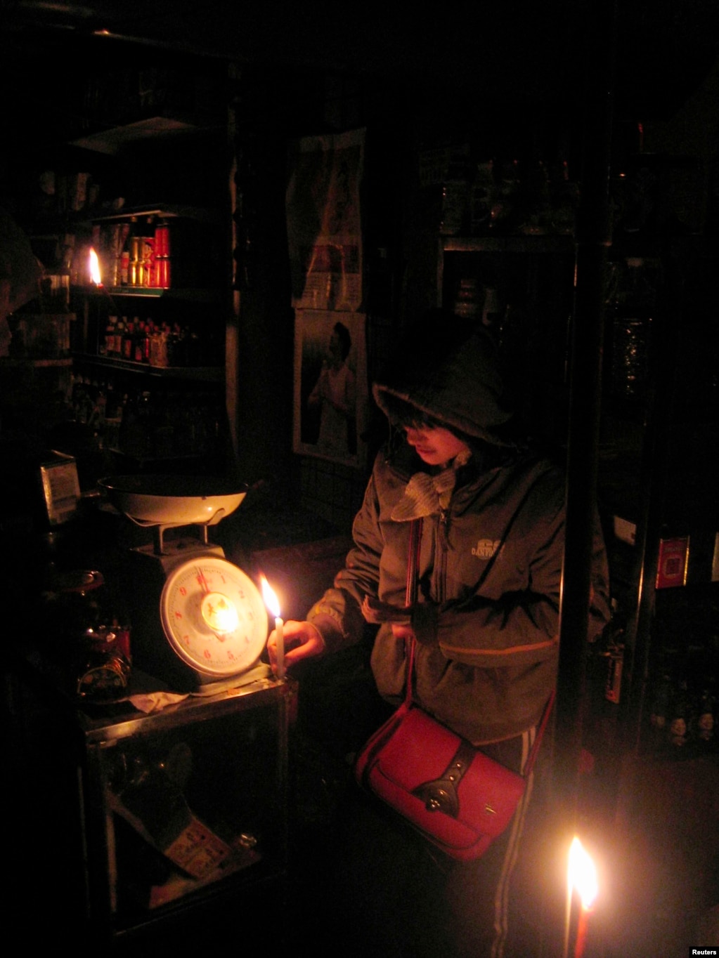 资料照：中国湖南郴州的一个小店里的商贩在蜡烛光里卖东西。(photo:VOA)