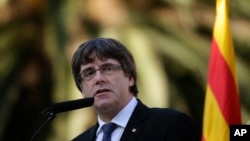 Catalan regional President Carles Puigdemont addresses to the media after a ceremony commemorating the 77th anniversary of the death of Catalan leader Lluis Companys at the Montjuic Cemetery in Barcelona, Spain, Oct. 15, 2017. 