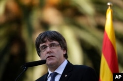 FILE - Catalan regional President Carles Puigdemont addresses to the media after a ceremony commemorating the 77th anniversary of the death of Catalan leader Lluis Companys at the Montjuic Cemetery in Barcelona, Spain, Oct. 15, 2017.