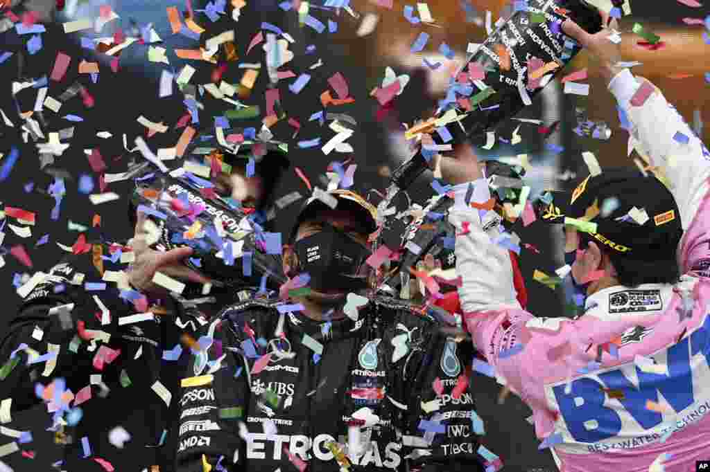 Second placed Racing Point driver Sergio Perez of Mexico, right, pours champagne on winner Mercedes driver Lewis Hamilton of Britain on the podium of the Formula One Turkish Grand Prix at the Istanbul Park circuit racetrack in Istanbul, Turkey.