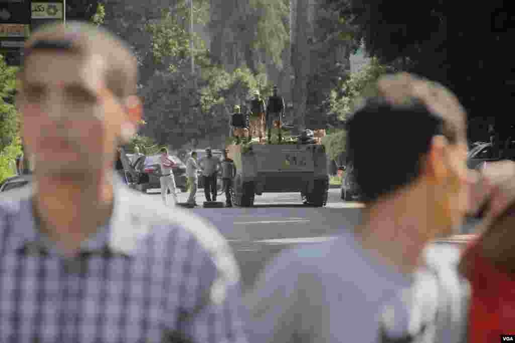 Egyptian security forces are seen over the shoulders of protesters in Maadi, southern Cairo, Sept. 20, 2013. (Hamada Elrasam for VOA)