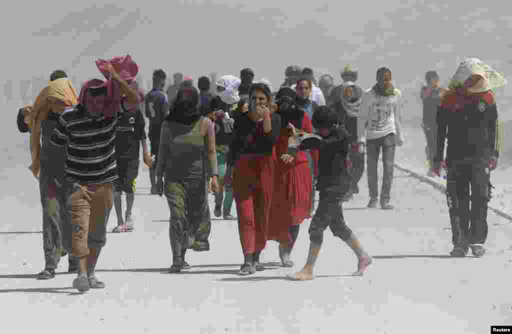 Para pengungsi dari sekte minoritas Yazidi berbaris dalam unjuk rasa di perbatasan Irak-Turki di distrik Zakho, provinsi Dohuk di wilayah otonom Kurdistan (17/8). (Reuters/Youssef Boudlal)
