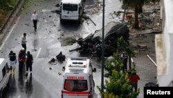 A destroyed van is pictured near a Turkish police bus which was targeted in a bomb attack in a central Istanbul district, Turkey, June 7, 2016.