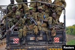 FILE - Uganda People's Defence Forces (UPDF) soldiers ride atop their military truck enroute to evacuate their citizens following recent fighting in Juba at Nimule town along the South Sudan and Uganda border, July 14, 2016.