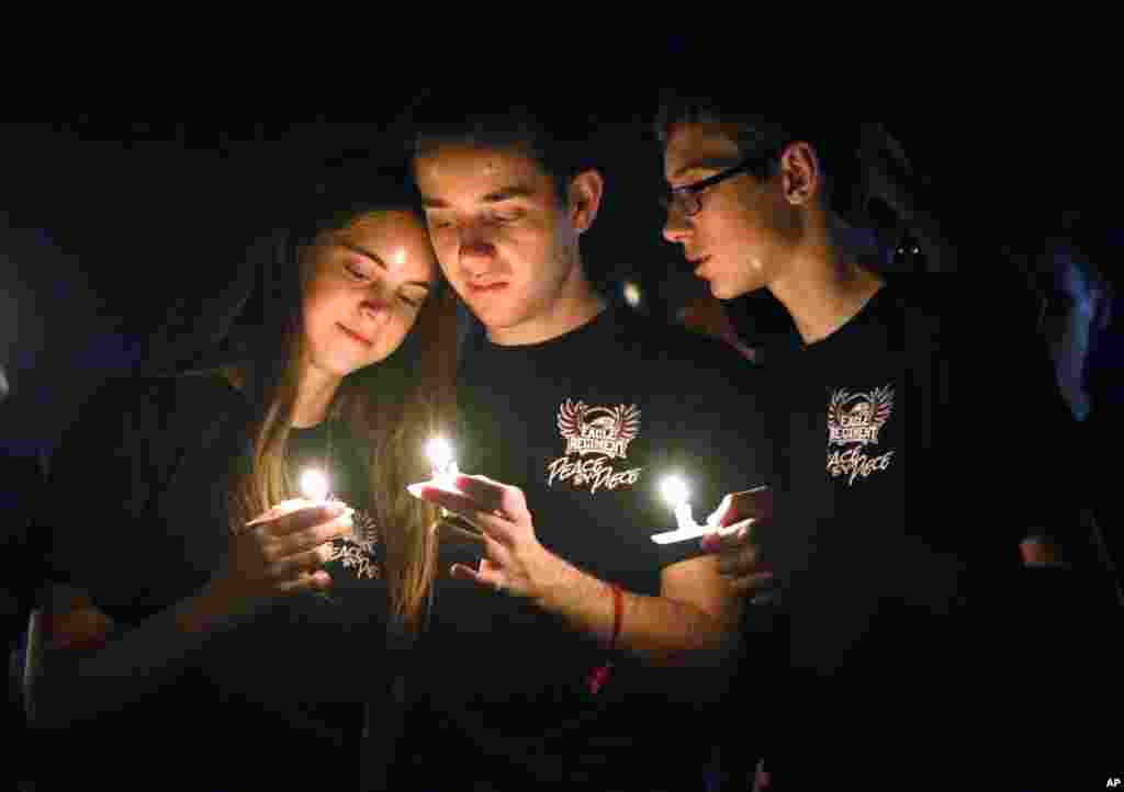 Attendees comfort each other at a candlelight vigil for the victims of the shooting at Marjory Stoneman Douglas High School, Feb. 15, 2018, in Parkland, Fla. 