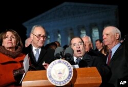 House Minority Leader Nancy Pelosi of Calif., left, and Senate Minority Leader Chuck Schumer of New York stand as Rep. Jerrold Nadler, D- N.Y., speaks in front of the Supreme Court in Washington about President Donald Trump's recent executive orders, Jan. 30, 2017. Standing at right is Sen. Ben Cardin, D-Md.