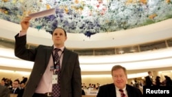 12일 스위스 제네바에서 열린 유엔 인권이사회에 참석한 미국의 로버트 킹 북한인권특사(오른쪽). 미국 대사관 직원(왼쪽)이 발언 신청을 하기 위해 명패를 들고 있다.