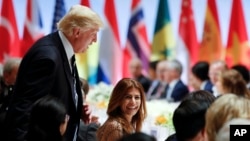 U.S. President Donald Trump visits with Argentina's president's wife Juliana Awada, from left, at the G20 summit dinner after a concert in Hamburg, Germany, July 7, 2017.