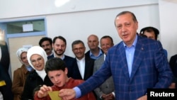 레제프 타이이프 에르도안(오른쪽) 터키 대통령이 16일 최대도시 이스탄불에서 지역 유권자들과 함께 개헌 국민투표에 참가하고 있다. 