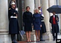 France's first lady Brigitte Macron, center-right, and her U.S. counterpart Melania Trump, center-left, stand on the steps of the Elysee Palace in Paris, France, Nov.10, 2018.