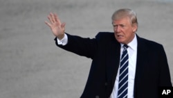 President Donald Trump waves as he walks towards Air Force One at Andrews Air Force Base in Md., Saturday, Dec. 2, 2017. Trump is heading to New York to attend a series of fundraisers. 