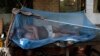 A laborer sleeps on a makeshift bed covered with a mosquito net on a hot summer morning in New Delhi, India, May 23, 2013. 