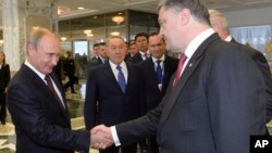 26일 벨라루스 수도 민스크에서 만난 러시아의 블라디미르 푸틴 대통령(왼쪽)과 우크라이나의 페트로 포로셴코 대통령이 악수하고 있다.