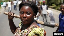 A female protester holds an axe during a protest against Burundian President Pierre Nkurunziza's decision to run for a third term in Bujumbura, Burundi, May 13, 2015.