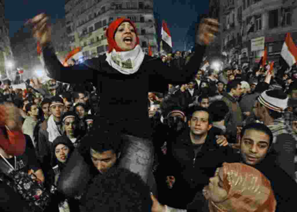 An Egyptian woman celebrates with other people after President Hosni Mubarak resigned and handed power to the military at Tahrir square, in Cairo, Egypt, Friday, Feb. 11, 2011. Egypt exploded with joy, tears, and relief after pro-democracy protesters brou