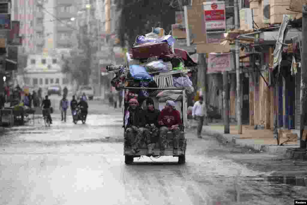 Free Syrian Army fighters sit on the back of a pick-up truck in the Mouazafeen neighbourhood in Deir al-Zor, Nov. 10, 2013. 