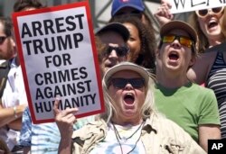 Activists hold signs to protest the Trump administration's approach to illegal border crossings and separation of children from immigrant parents, June 30, 2018, in Salt Lake City.