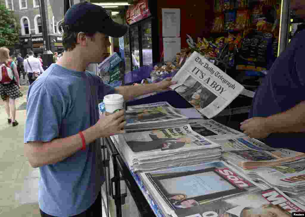 A man buys a newspaper displaying the news of the royal birth by Britain&#39;s Catherine, Duchess of Cambridge, central London, July 23, 2013.