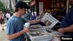 A man buys a newspaper displaying the news of the Royal birth by Britain's Catherine, Duchess of Cambridge in central London, July 23, 2013. Already touted as one of the most famous babies in the world, the first child of Prince William and wife Kate face