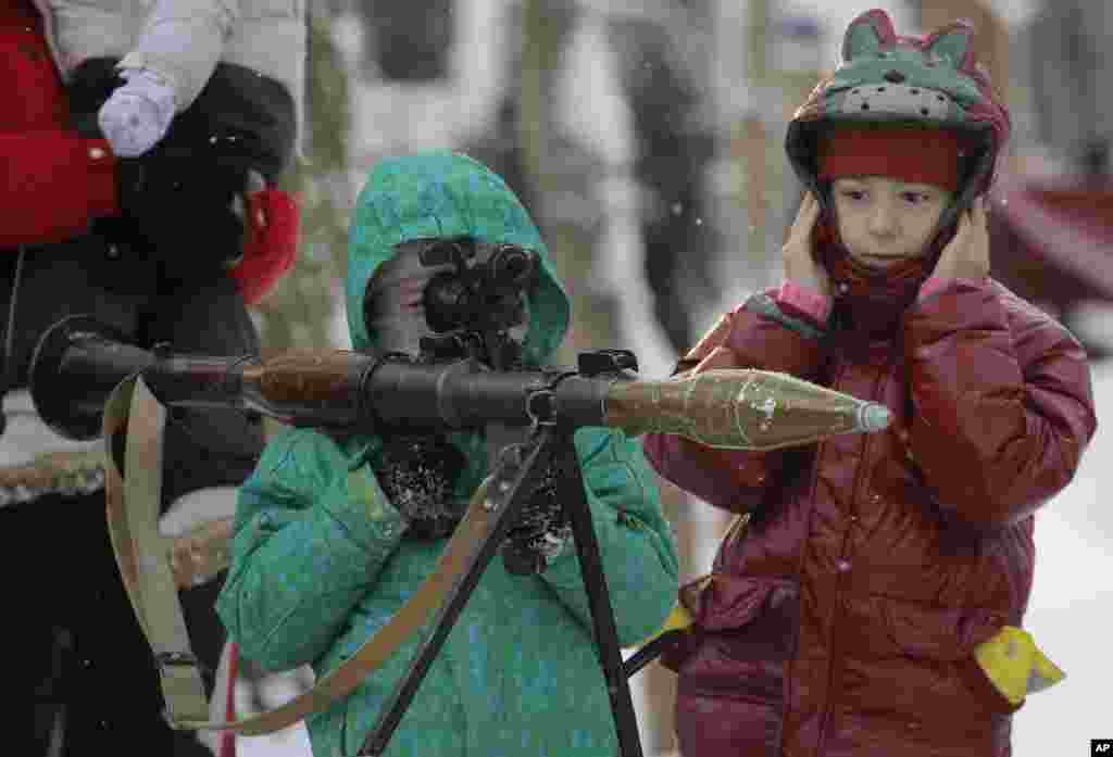 A boy aims an RPG at a weapons exhibition during a military show in St.Petersburg, Russia.