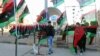 Men sell Libyan flags as they mark the third anniversary of the February 17 uprising against Moammar Gadhafi in Benghazi, February 16, 2014.